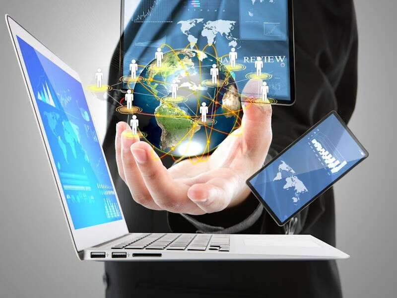 Globe numÃ©rique tenu au-dessus d'un ordinateur portable