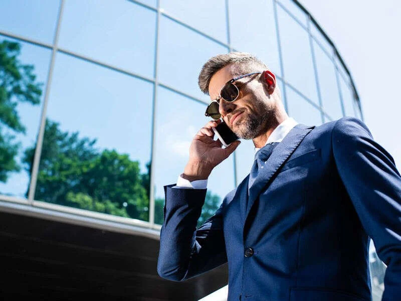 Dirigeant au téléphone devant un immeuble de bureaux